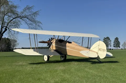 1930 Waco ASO NC119Y parked on the grass, a Straightwing Waco now often called a PSO