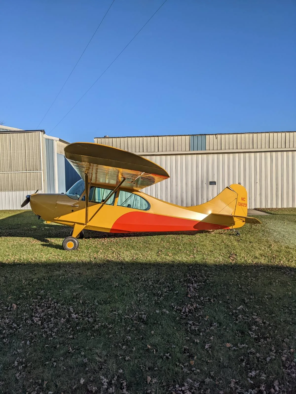 Yellow antique aircraft parked outside